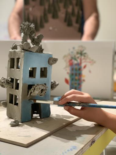 casa in ceramica con bambino che la dipige